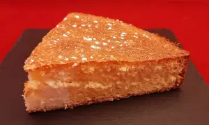 Tranche de gâteau de Savoie aérien, saupoudrée de sucre glace. Une recette facile avec fécule pour un dessert léger.