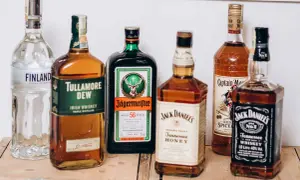 Plusieurs bouteilles d'alcool, dont du whisky, prêtes pour un digestif.
