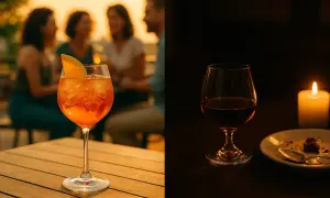 Un cocktail orange pétillant et un verre de digestif ambré, éclairé par une bougie.