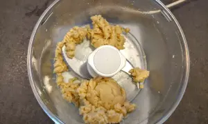 Pâte d'amande maison dans un robot culinaire, prête à être façonnée en délicieuses friandises.