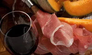 Un verre de vin rouge, du melon et du jambon cru. Quel vin avec melon et jambon cru ? Une belle association pour un apéritif gourmand.