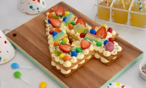 Un délicieux number cake 10 ans, décoré de fraises, bonbons arc-en-ciel et pépites colorées, prêt pour une fête d'anniversaire.