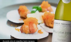 Coquilles Saint-Jacques garnies de caviar orange, accompagnées d'une bouteille de Chablis. Quel vin avec coquille saint jacques ? Un accord parfait.