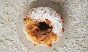 Un Paris-Brest aérien, garni d'une crème onctueuse au praliné noisette, saupoudré de sucre glace et d'amandes effilées.