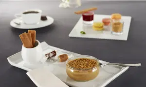 Un café gourmand avec diverses mignardises : crème dessert, macarons, biscuits, chocolats. Parfaites pour des recettes de mignardises pour café gourmand.
