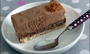Une part de **Trianon gâteau** au chocolat, légère et aérienne, sur une assiette blanche avec une cuillère à pois.