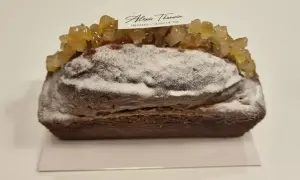 Gâteau moelleux au citron, saupoudré de sucre glace et garni de fruits confits. Une pâtisserie Alexis Thauvin.
