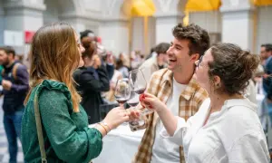 Trois amis trinquent avec des verres de vin rouge, célébrant peut-être la vin primeur définition. Ambiance festive.