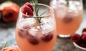 Un délicieux cocktail sans alcool Saint-Valentin, garni de framboises fraîches et d'une touche de romarin. Parfait pour célébrer l'amour !