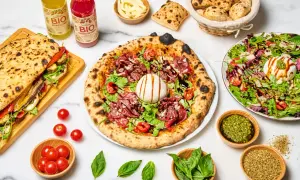 Une pizza savoureuse, un sandwich garni, une salade fraîche et des boissons. Quel vin avec pizza ? Un repas italien parfait pour partager.