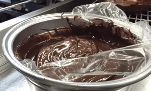 Ganache montée au chocolat dans un bol, prête pour la conservation au frigo.