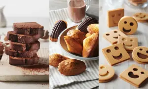 Tranches de cake au chocolat, madeleines et biscuits souriants. Parfait pour une recette goûter gourmande.