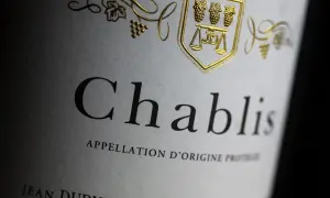 Étiquette d'un Chablis, vin blanc sec ou moelleux, avec un blason doré orné de grappes de raisin.