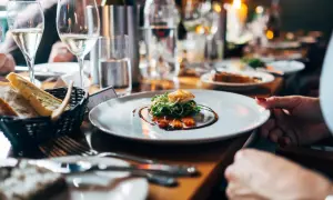 Un dîner élégant avec du vin pétillant, du saumon fumé et du pain frais. Une table dressée pour une occasion spéciale, avec des fruits de mer et des boissons.