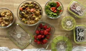 Préparation pour le batch cooking du goûter : ratatouille, poivrons coupés, fraises et autres ingrédients dans des boîtes hermétiques.