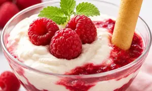 Un délice crémeux avec des framboises fraîches et un biscuit, évoquant une délicieuse ganache framboise.