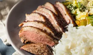 Tranches de magret de canard, riz blanc et légumes. Un plat savoureux qui invite à se demander : que boire avec du magret de canard ?