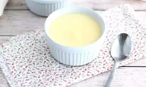 Deux ramequins de crème dessert rapide sans cuisson sur une serviette fleurie, avec une cuillère.