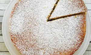 Un délicieux victoria sponge cake, saupoudré de sucre glace, avec une part déjà coupée. Parfait pour le thé !