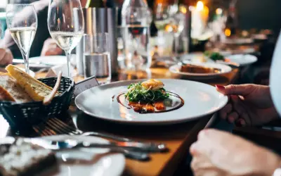 Un dîner élégant avec du vin pétillant, du saumon fumé et du pain frais. Une table dressée pour une occasion spéciale, avec des fruits de mer et des boissons.