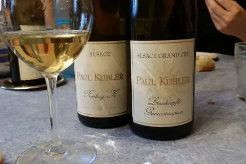 Verre de vin blanc d'Alsace, deux bouteilles Paul Kubler. Quel vin pour la choucroute ? Un Riesling ou un Gewurztraminer ?