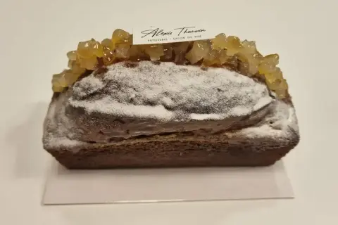 Gâteau moelleux au citron, saupoudré de sucre glace et garni de fruits confits. Une pâtisserie Alexis Thauvin.