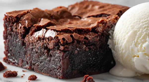 Un brownie au chocolat fondant, parfait pour une recette facile, servi avec une boule de glace à la vanille.