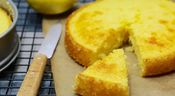 Un délicieux gâteau express au citron, tout juste sorti du four, avec une part coupée et un couteau à portée de main.