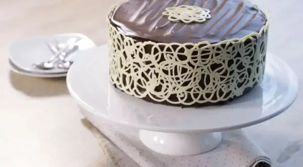 Gâteau au chocolat riche et dense, un vrai "mud cake", décoré d'une dentelle de chocolat blanc.