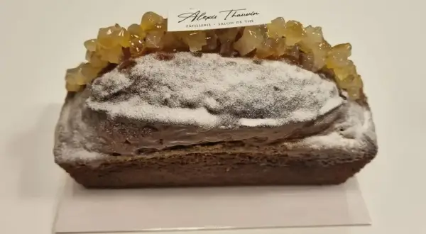 Gâteau moelleux au citron, saupoudré de sucre glace et garni de fruits confits. Une pâtisserie Alexis Thauvin.