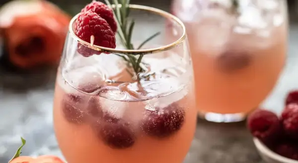 Un délicieux cocktail sans alcool Saint-Valentin, garni de framboises fraîches et d'une touche de romarin. Parfait pour célébrer l'amour !