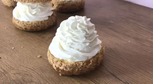 Choux garnis d'une généreuse crème mascarpone vanille, prêts à être dégustés sur fond de bois.