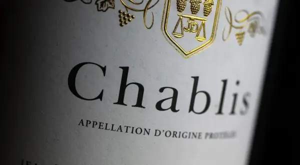 Étiquette d'un Chablis, vin blanc sec ou moelleux, avec un blason doré orné de grappes de raisin.