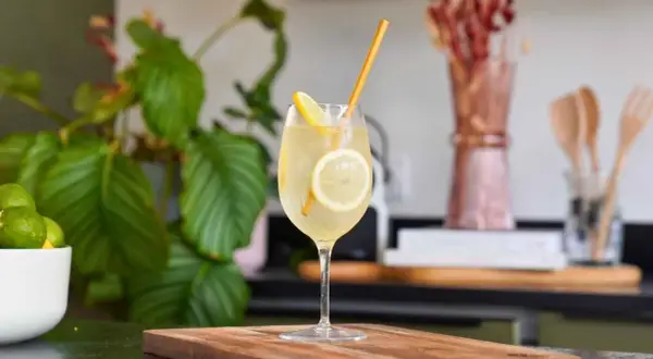 Un cocktail pétillant à la limoncello, garni de rondelles de citron et d'une paille dorée. Une recette rafraîchissante pour l'été.