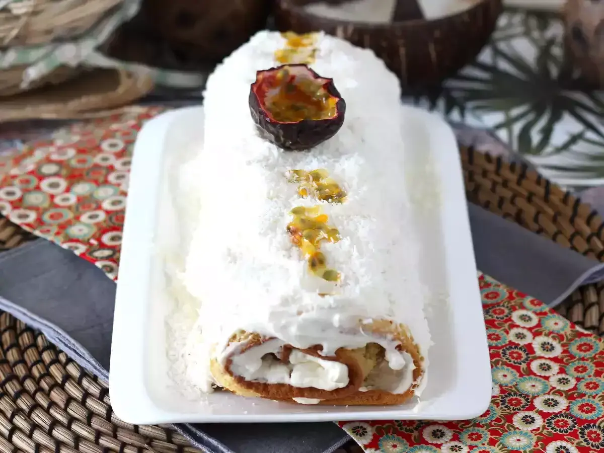 Bûche roulée recouverte d'une onctueuse crème noix de coco et de fruits de la passion. Un délice tropical !