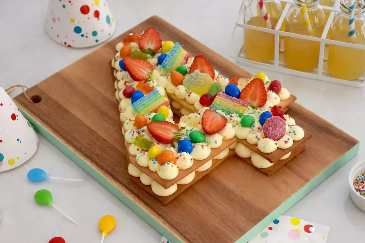 Un délicieux number cake 10 ans, décoré de fraises, bonbons arc-en-ciel et pépites colorées, prêt pour une fête d'anniversaire.