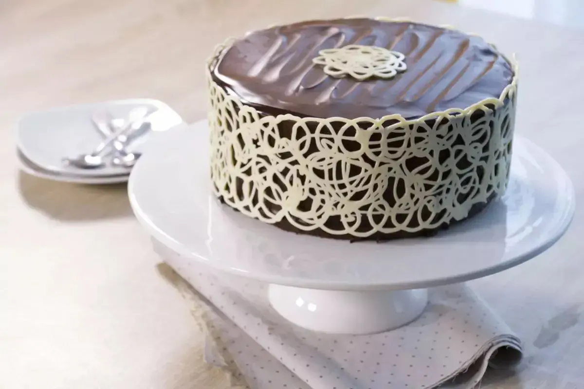 Gâteau au chocolat riche et dense, un vrai "mud cake", décoré d'une dentelle de chocolat blanc.