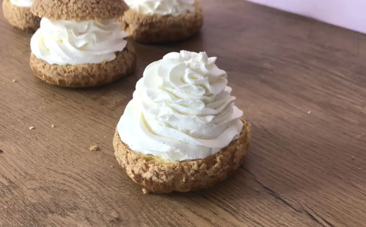 Choux garnis d'une généreuse crème mascarpone vanille, prêts à être dégustés sur fond de bois.