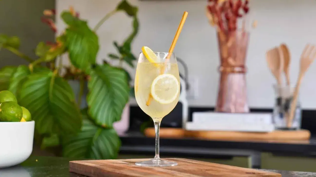 Un cocktail pétillant à la limoncello, garni de rondelles de citron et d'une paille dorée. Une recette rafraîchissante pour l'été.