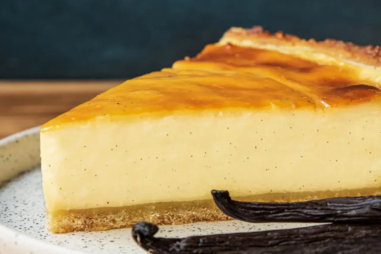 Tranche de flan pâtissier à la vanille, parfait pour une recette flan sans pâte marmiton. La texture est lisse et crémeuse, avec des points de vanille visibles.
