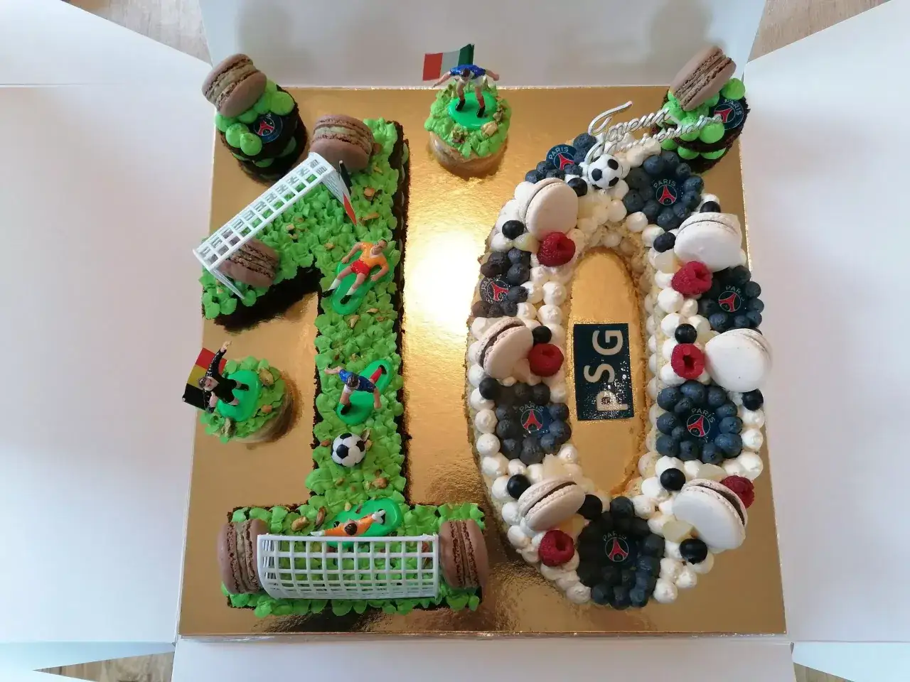 Un spectaculaire number cake 10 ans sur le thème du football, décoré de macarons, fruits et figurines de joueurs.