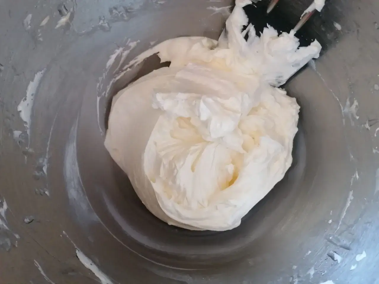 Mélange crémeux et aérien dans un bol, prêt à devenir une délicieuse meringue suisse.