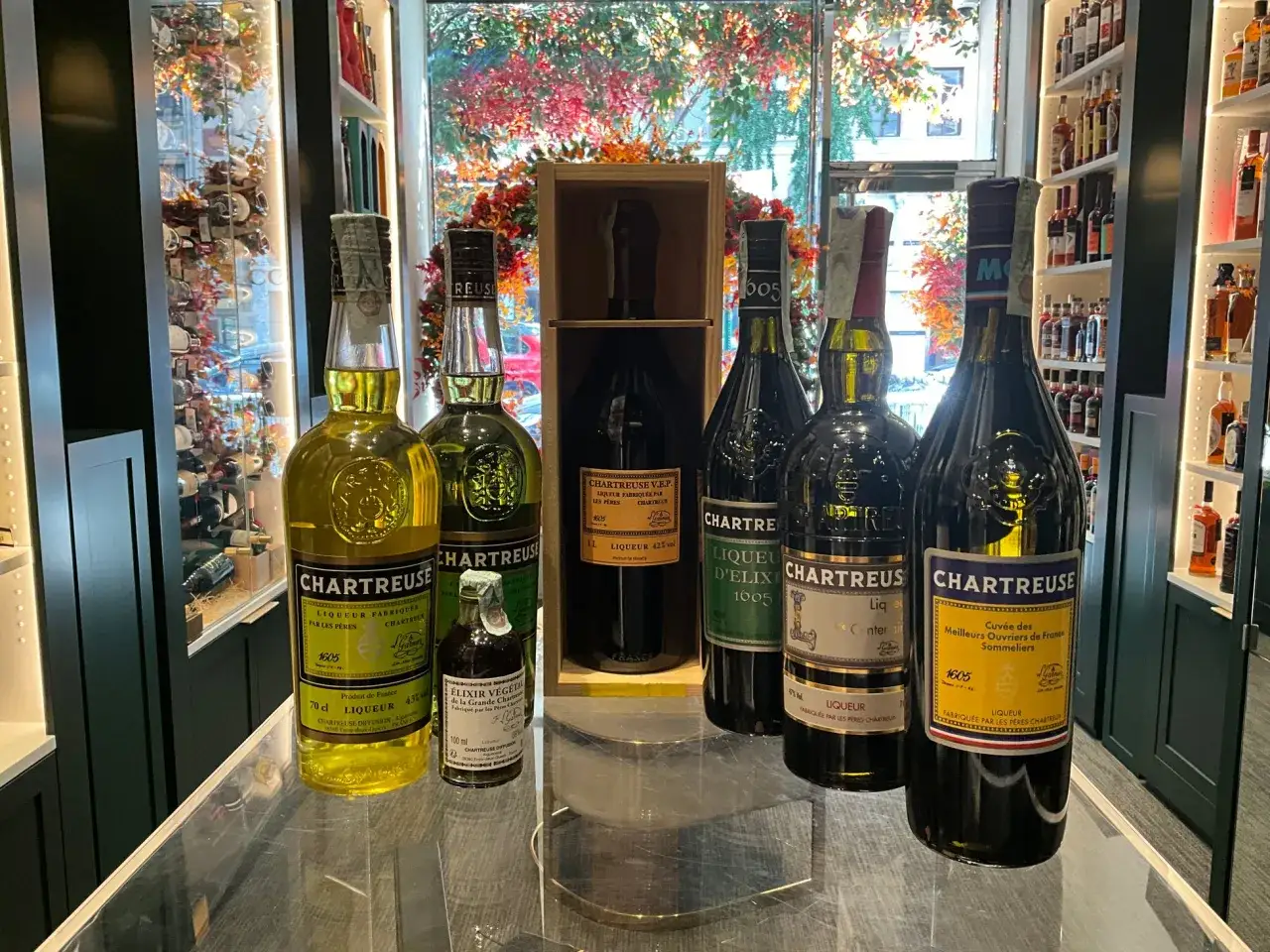 Plusieurs bouteilles de Chartreuse, liqueur verte et jaune, sont présentées. C'est quoi une Chartreuse ? Une liqueur monastique française.
