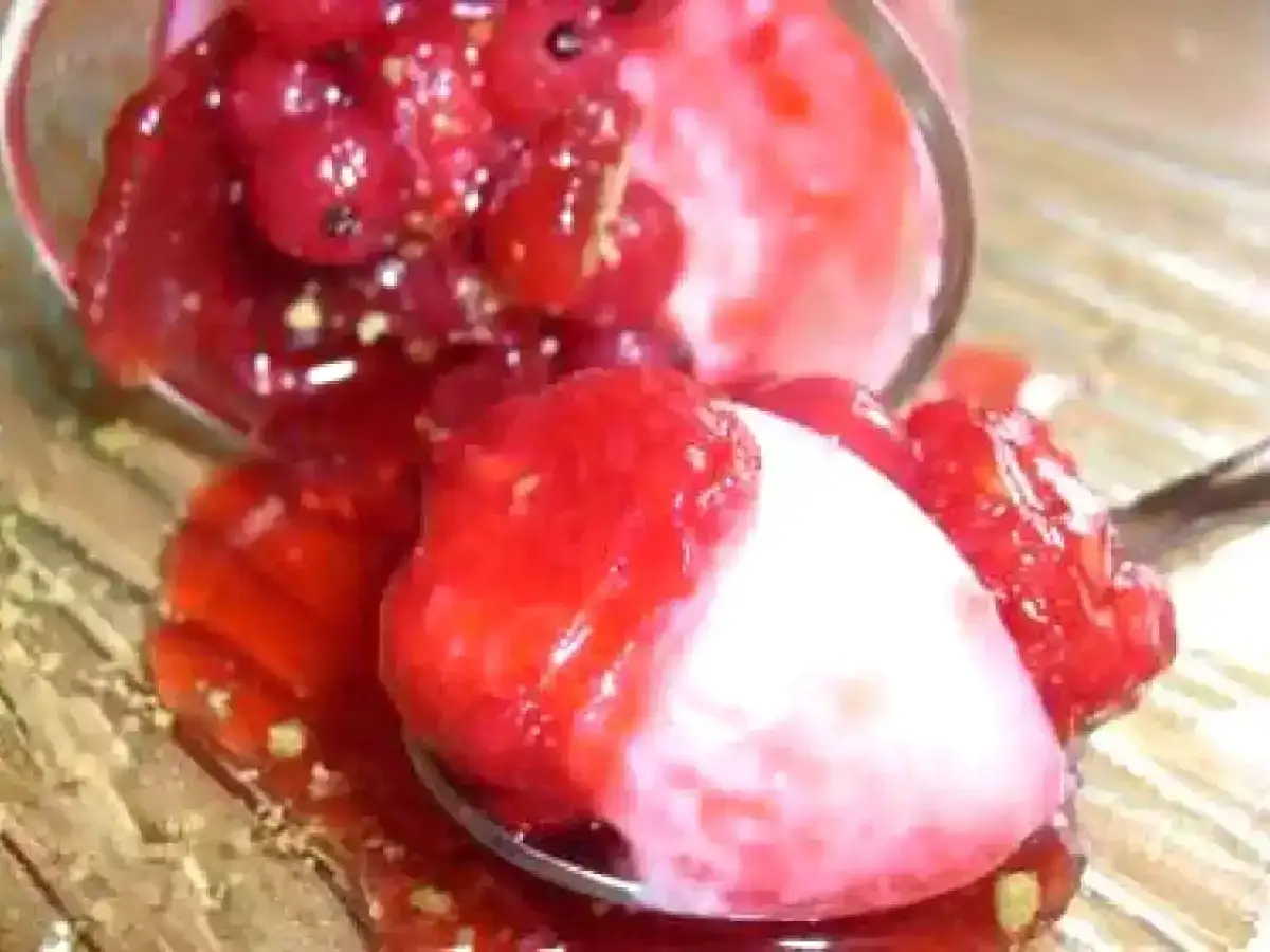 Cuillère remplie de crème noix de coco et de fruits rouges, un délice onctueux et acidulé.