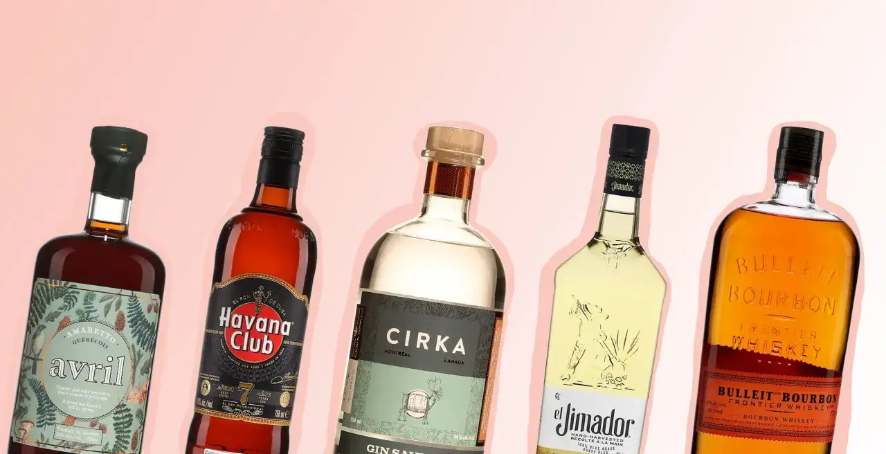 Cinq bouteilles d'alcool, dont un amaretto, un rhum, un gin, une tequila et un bourbon, parfaites pour créer un cocktail.