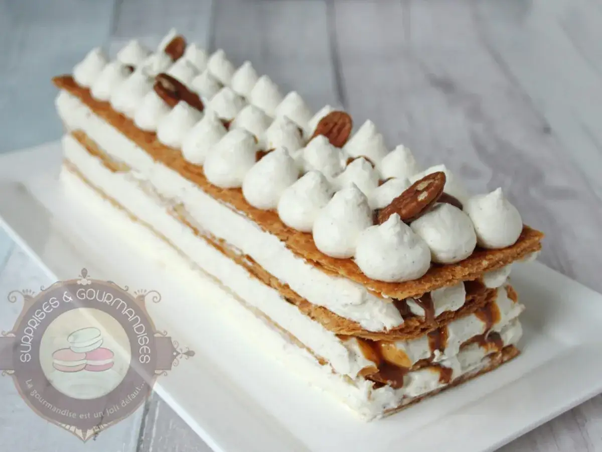Millefeuille aérien garni de crème vanillée et d'une délicieuse ganache praliné, surmonté de noix de pécan.