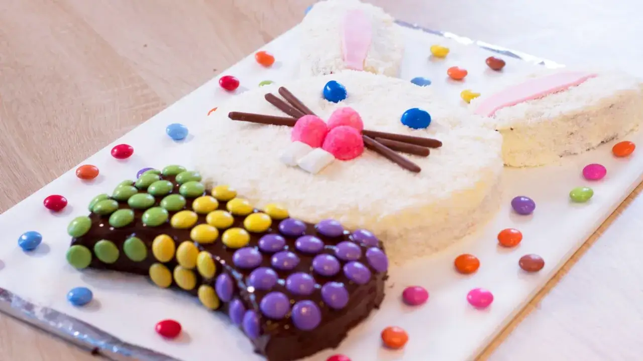 Un adorable lapin en gâteau coco, décoré de bonbons colorés. Un dessert de Pâques facile et festif pour toute la famille.