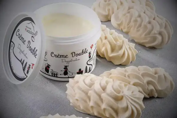 Douceur aérienne : des meringues suisses parfaites accompagnent un pot de crème double Moleson.