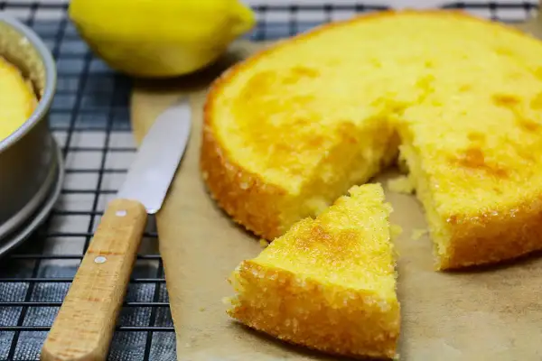 Un délicieux gâteau express au citron, tout juste sorti du four, avec une part coupée et un couteau à portée de main.