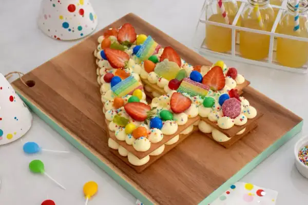 Un délicieux number cake 10 ans, décoré de fraises, bonbons arc-en-ciel et pépites colorées, prêt pour une fête d'anniversaire.